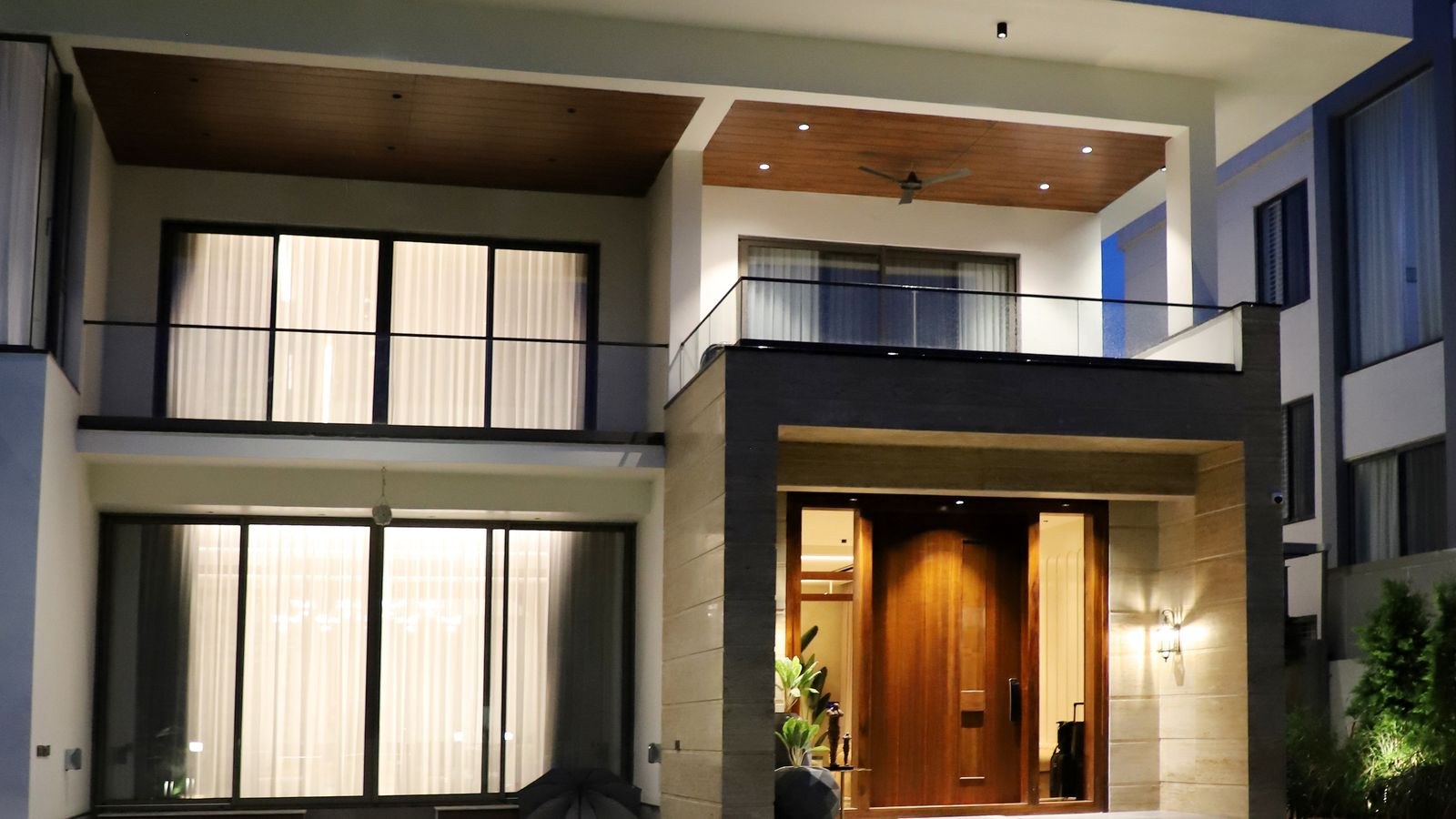 Luxury home exterior at night showing landscape spotlight wall washing
