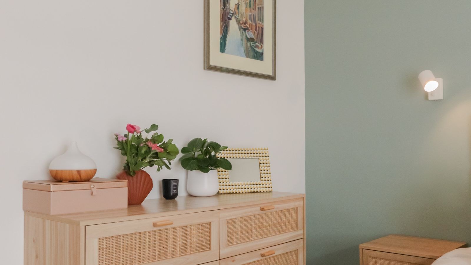Wooden dresser anchored against a bedroom wall with plants and artwork