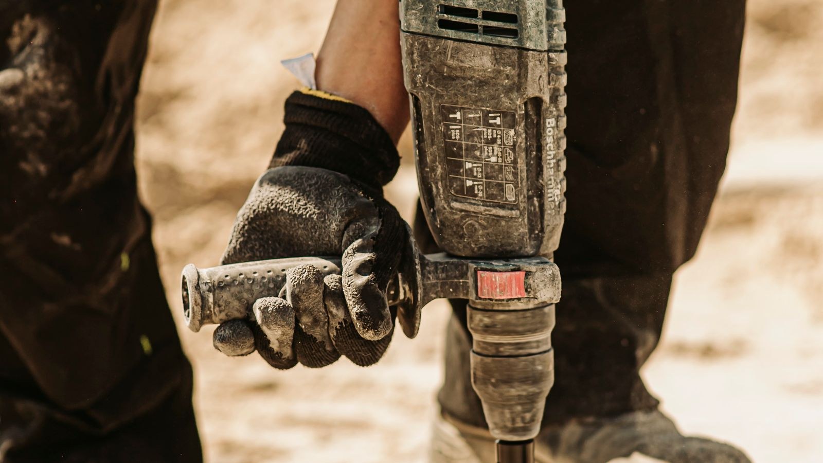 Hammer drill boring an anchor hole into a concrete floor slab