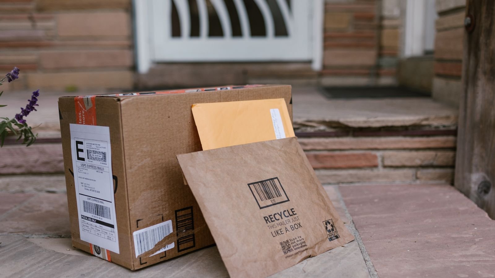 Close-up of delivered parcels on a doorstep beside a front door