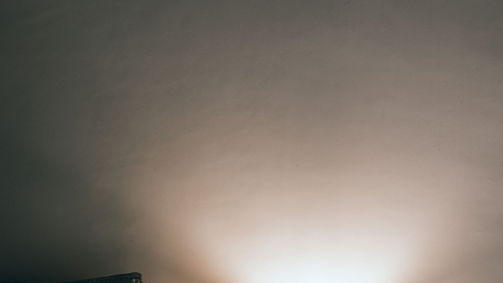 Warm amber light bulb glowing softly in a living room lamp in the evening