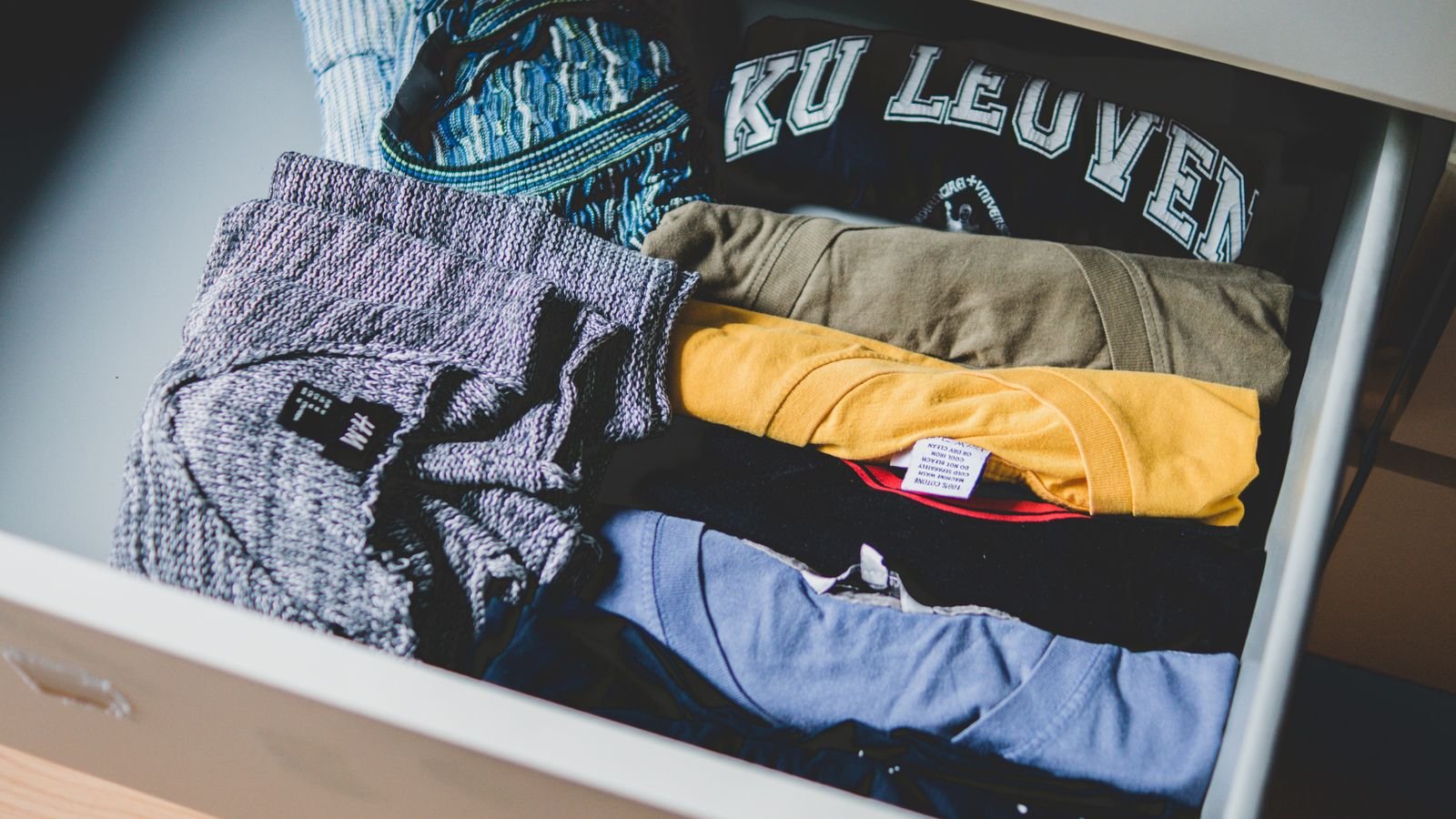 Folded winter sweaters and coats organised for seasonal storage