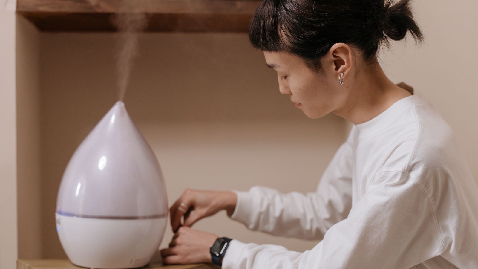 Person cleaning and refilling a humidifier tank at home