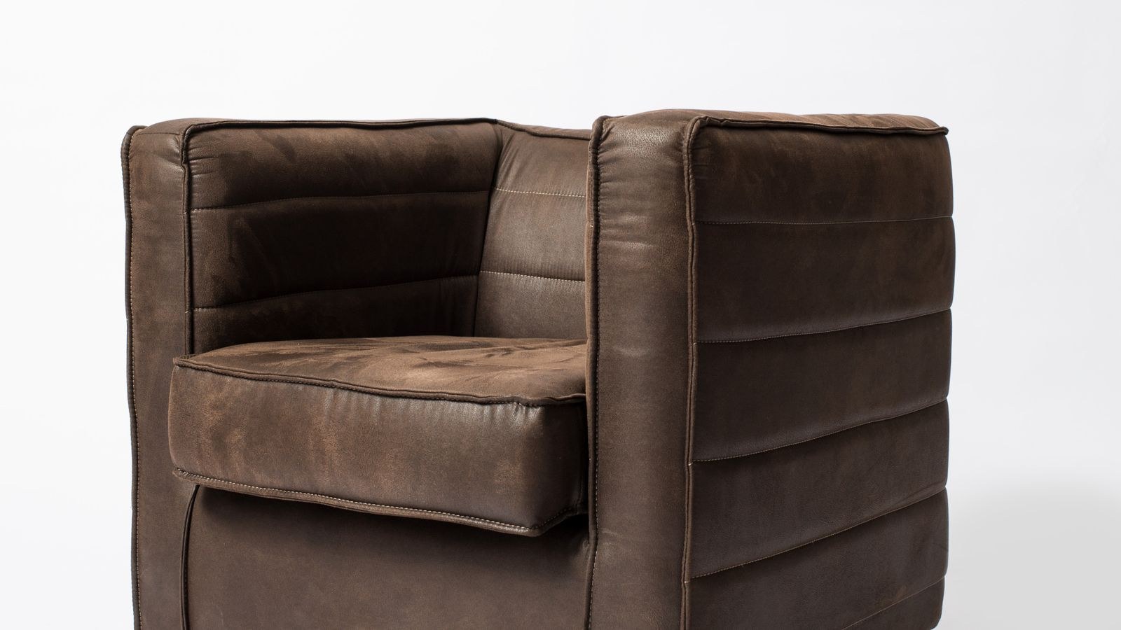 Leather chair upholstery close up showing grain texture and stitching