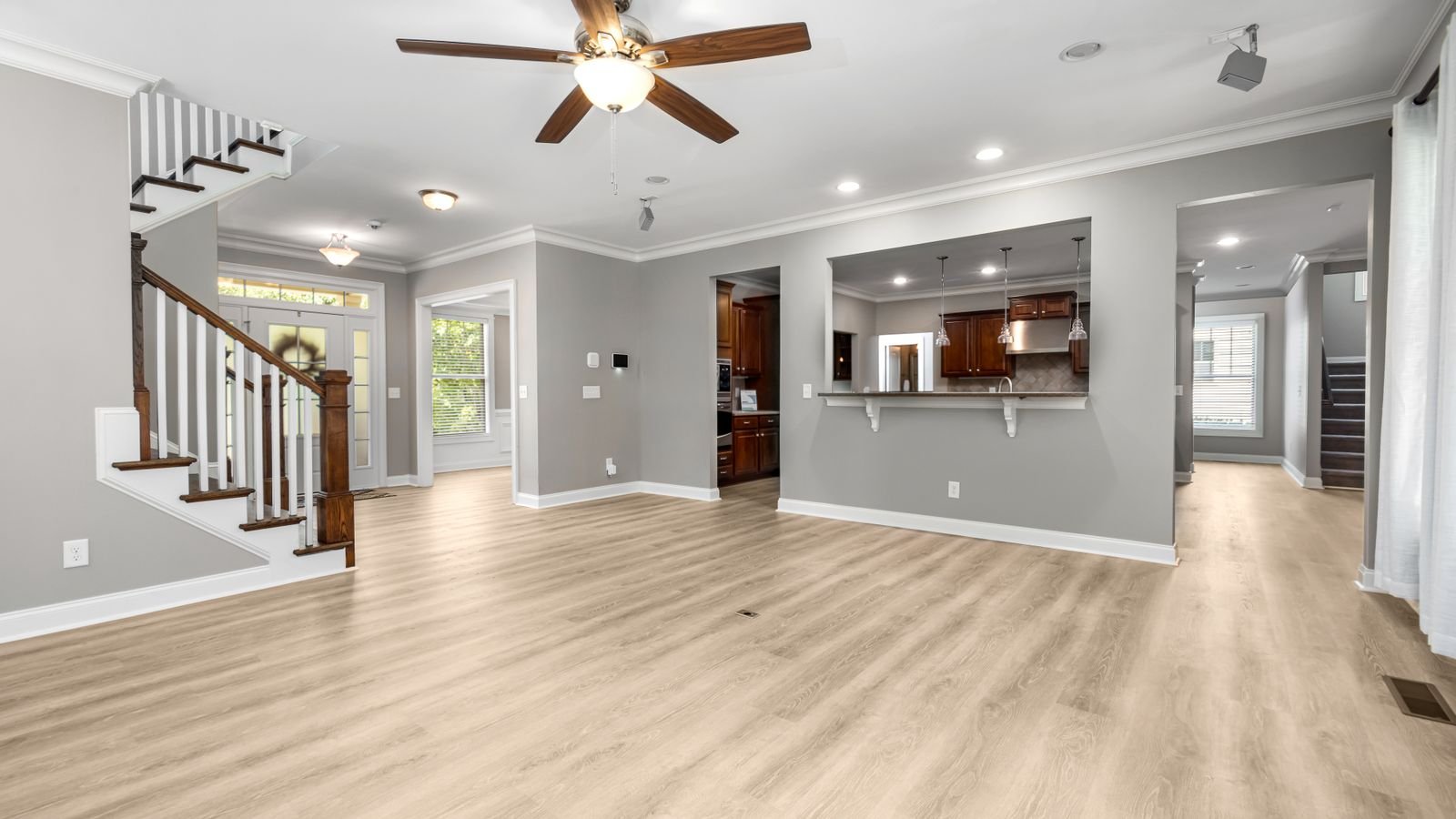 Open plan living space with a ceiling fan and wooden flooring