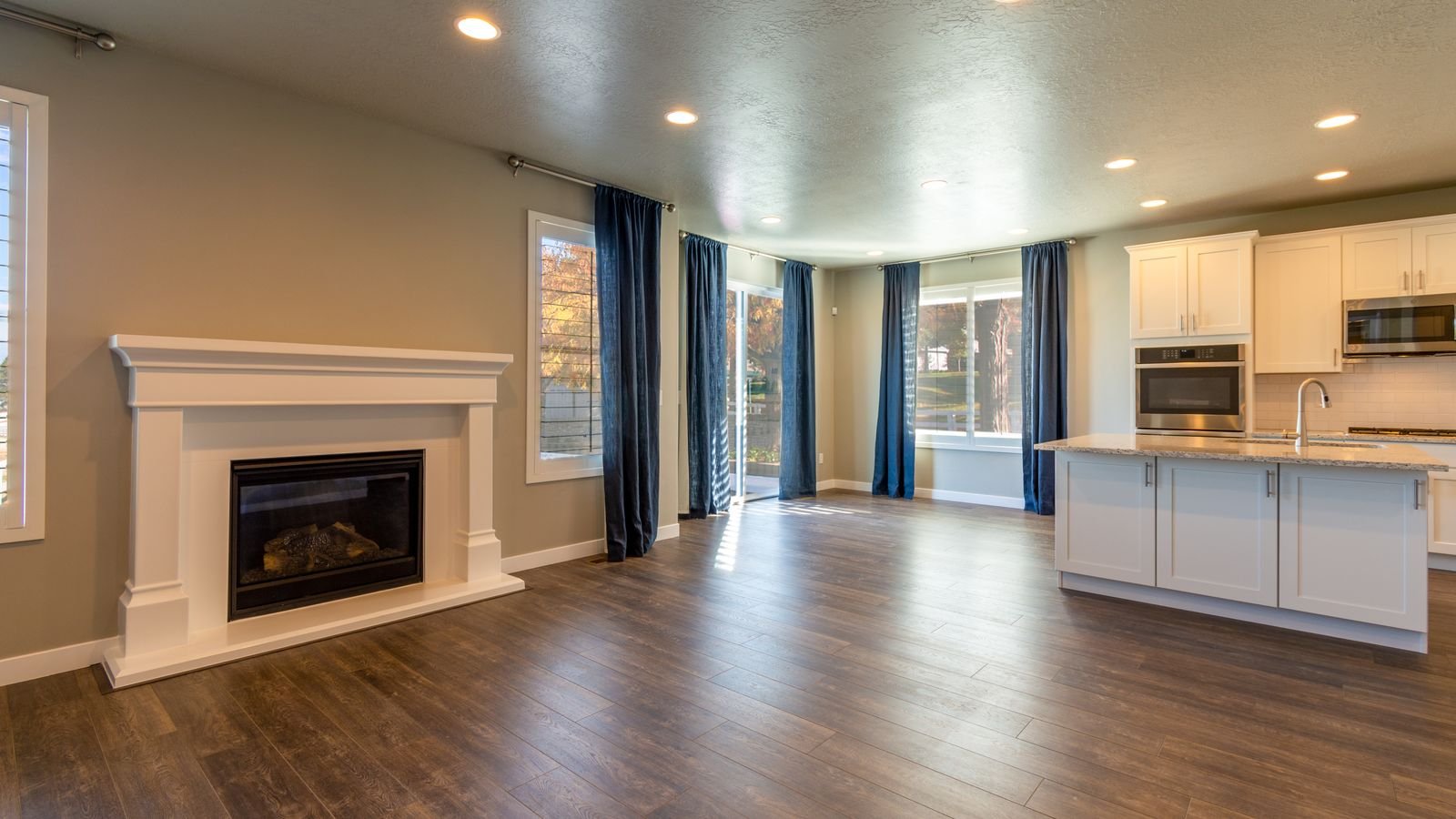 Open plan kitchen and living area lit by retrofit LED recessed lights