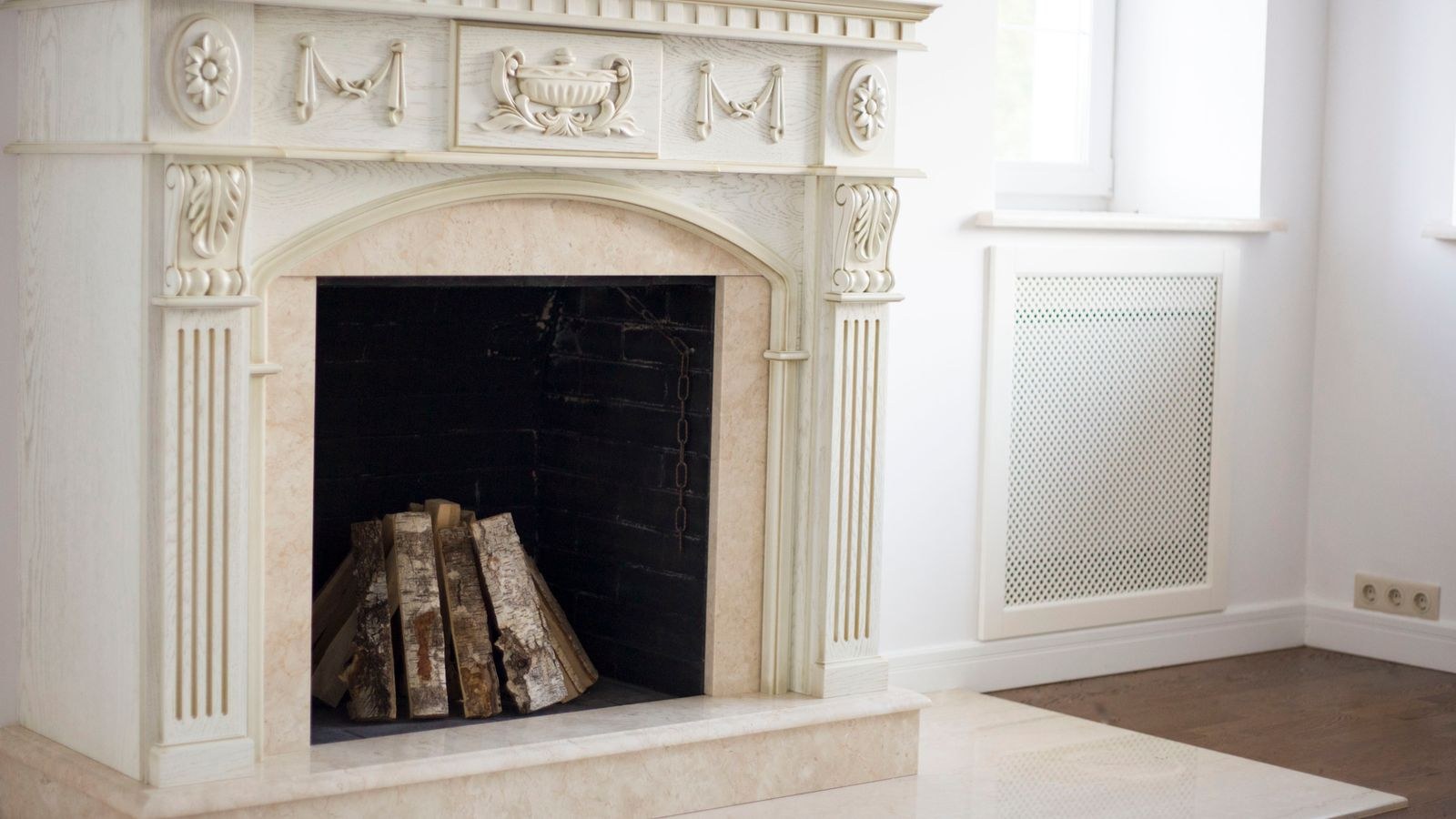 Decorated fireplace mantel with layered greenery candles and string lights