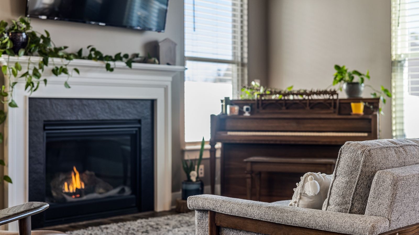 Fireplace mantel decorated with garland and warm white string lights at night