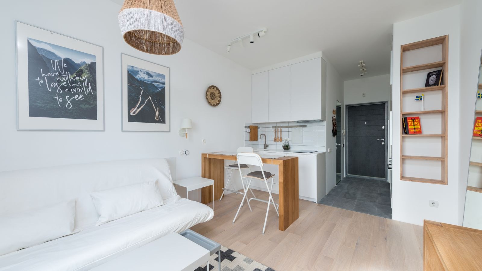Small rental apartment corner with curtains freestanding shelving and layered textiles
