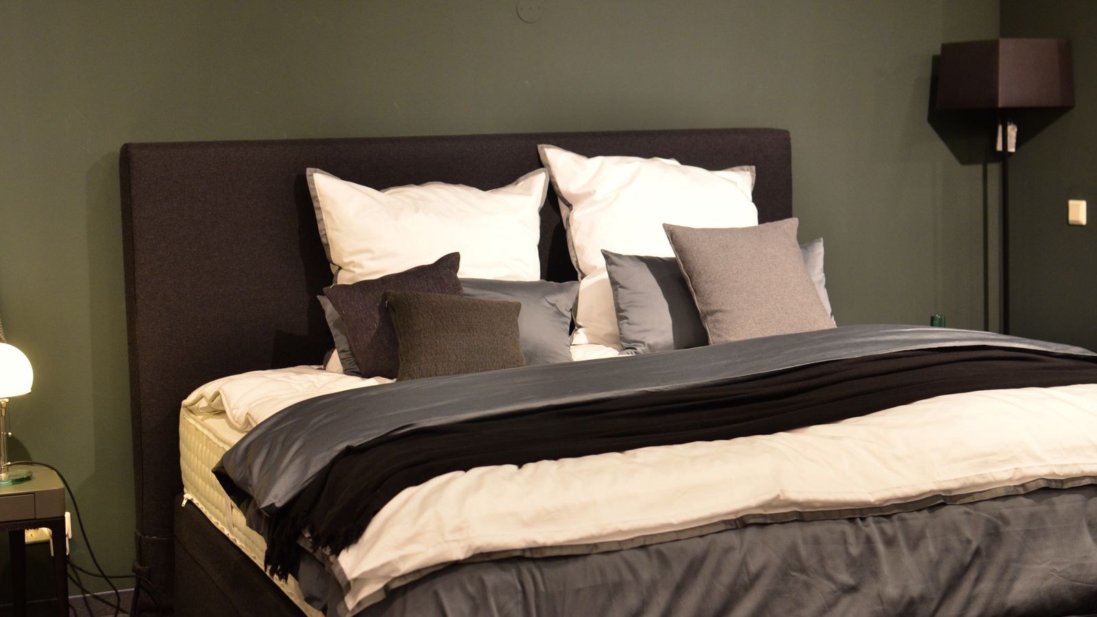 Clean fresh mattress with bedding stripped back in a bright bedroom