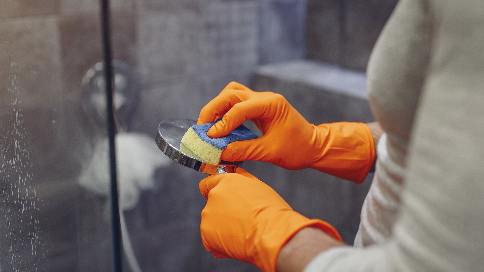 Cleaning shower head nozzles by hand to remove hard water limescale