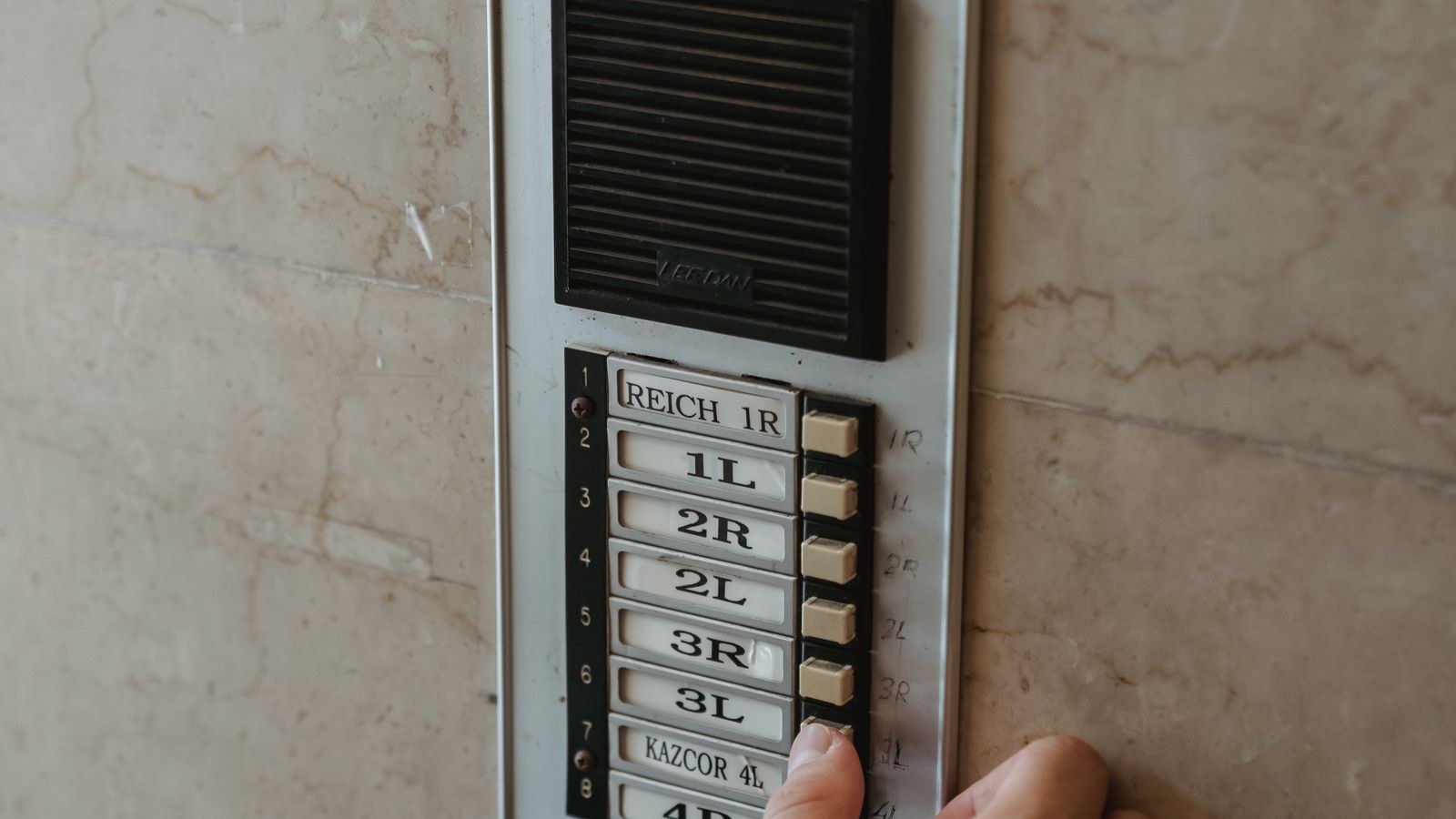 Hand pressing a doorbell button that keeps ringing by itself