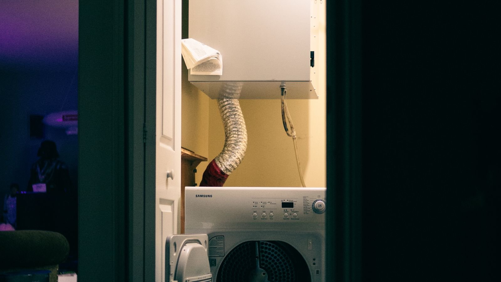 White front load washing machine installed in a laundry closet