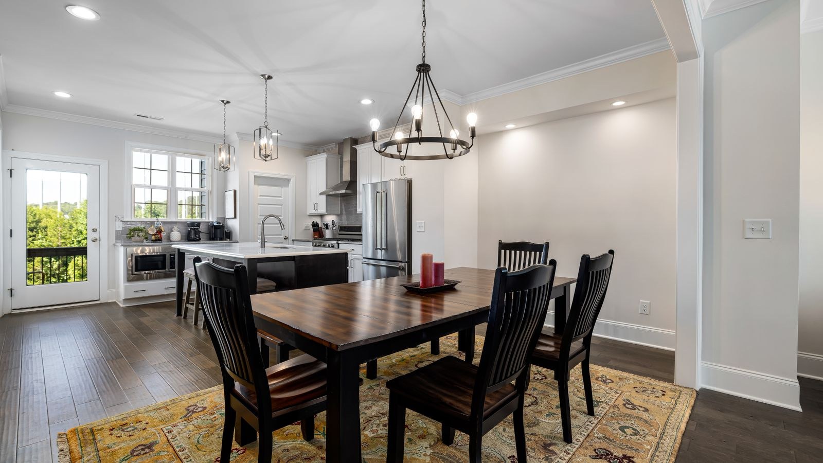 Dining room chandelier centered above a rectangular wood dining table