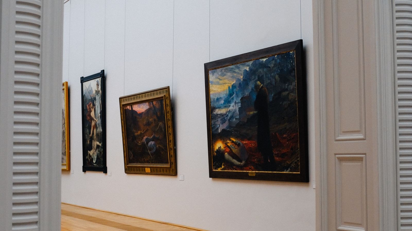 Framed prints hung in a straight grid layout on a light interior wall