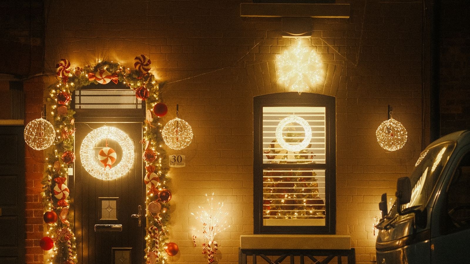 House exterior illuminated with Christmas lights along the roofline at night