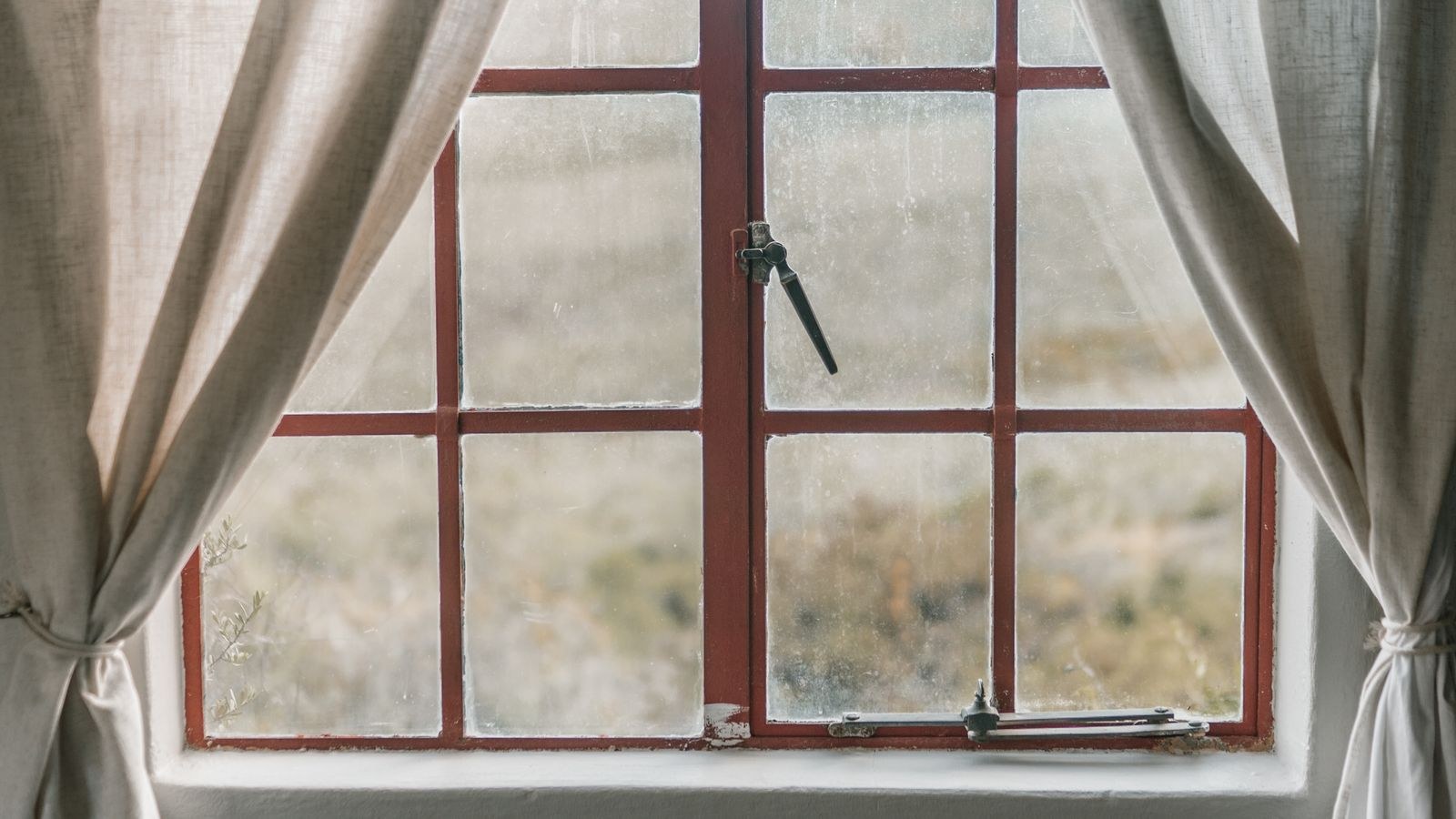 Curtain rod bracket mounted high on the wall above a window frame