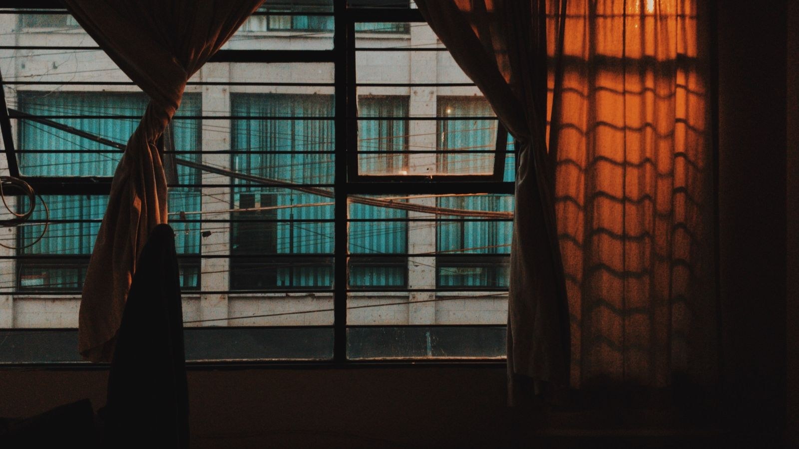 Full length curtain panels stacked wide beside a window letting in daylight