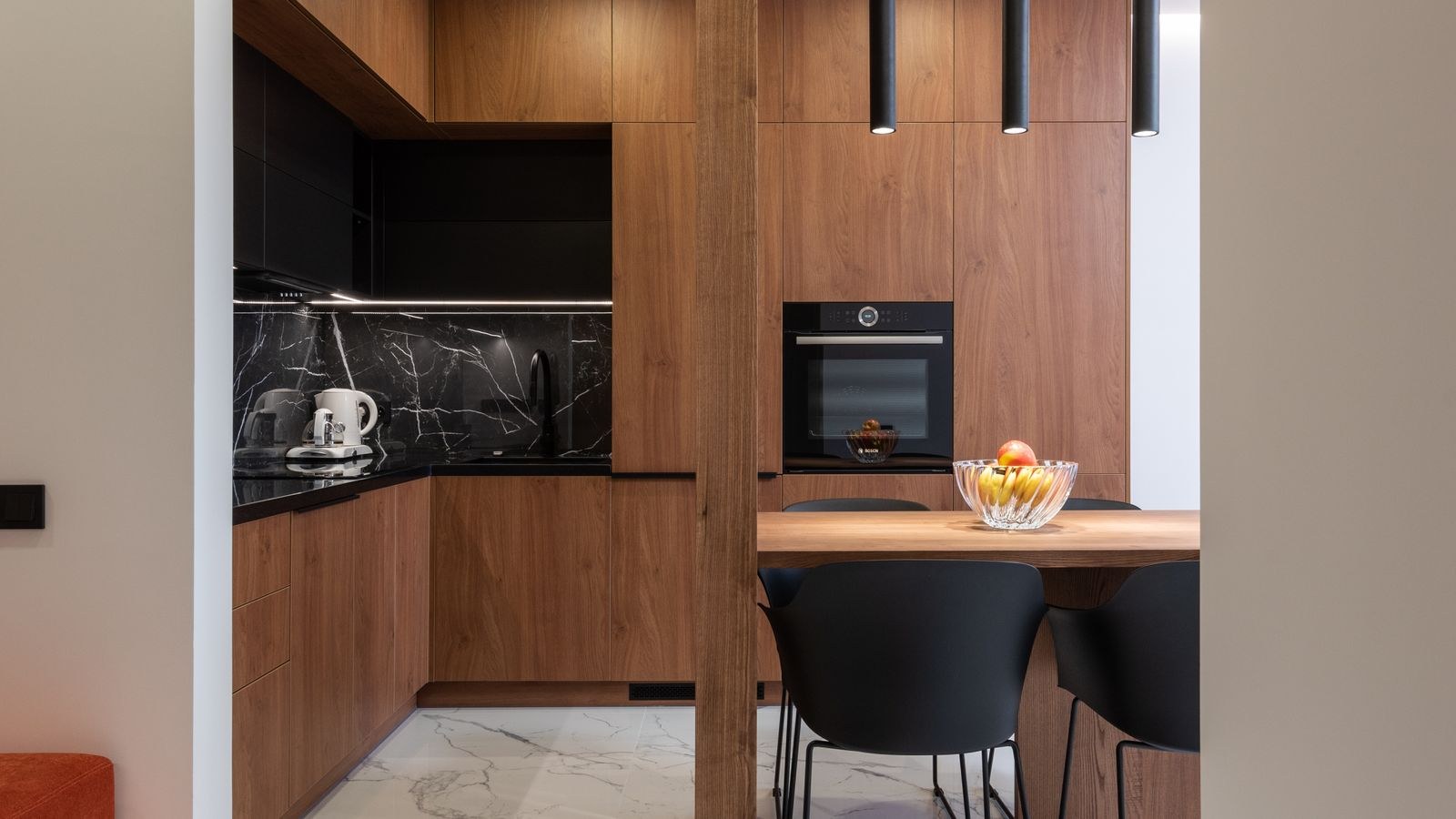 Dimmed under cabinet lighting glowing over a kitchen backsplash