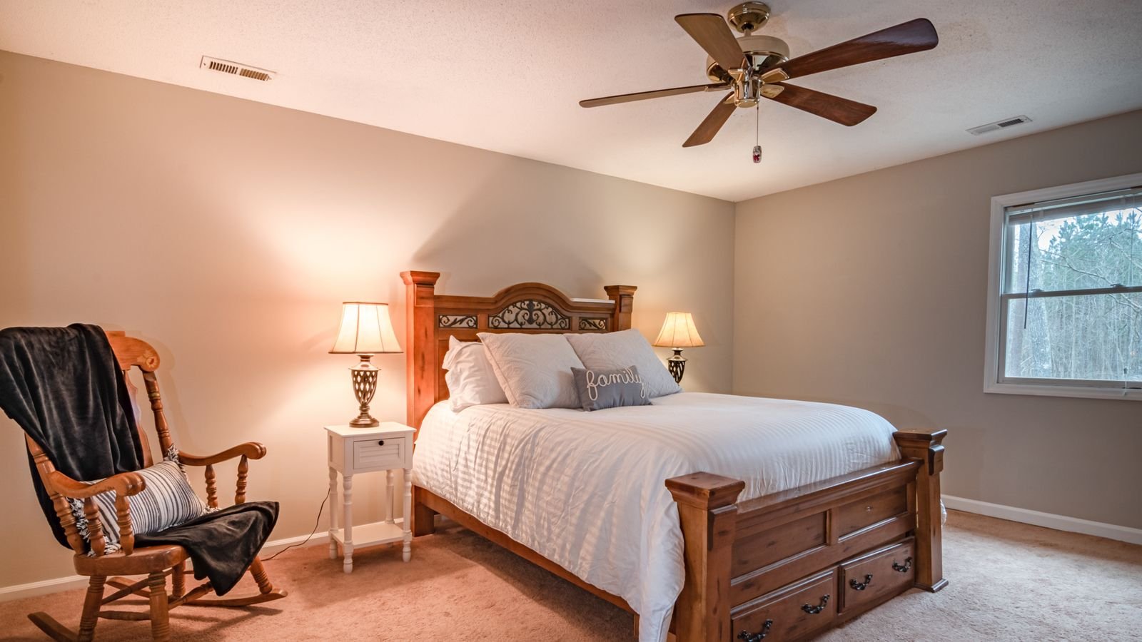Bedroom interior with a ceiling fan installed above a wooden bed