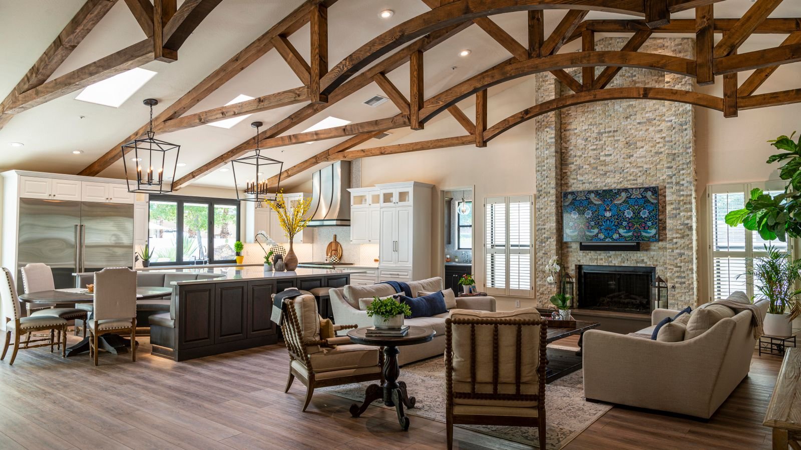 Ceiling fan hanging from a long downrod in a room with a sloped cathedral ceiling