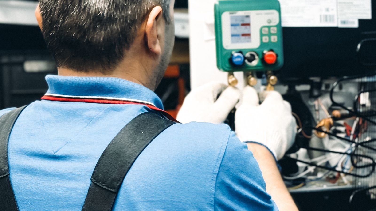 Technician performing air conditioning installation and maintenance work