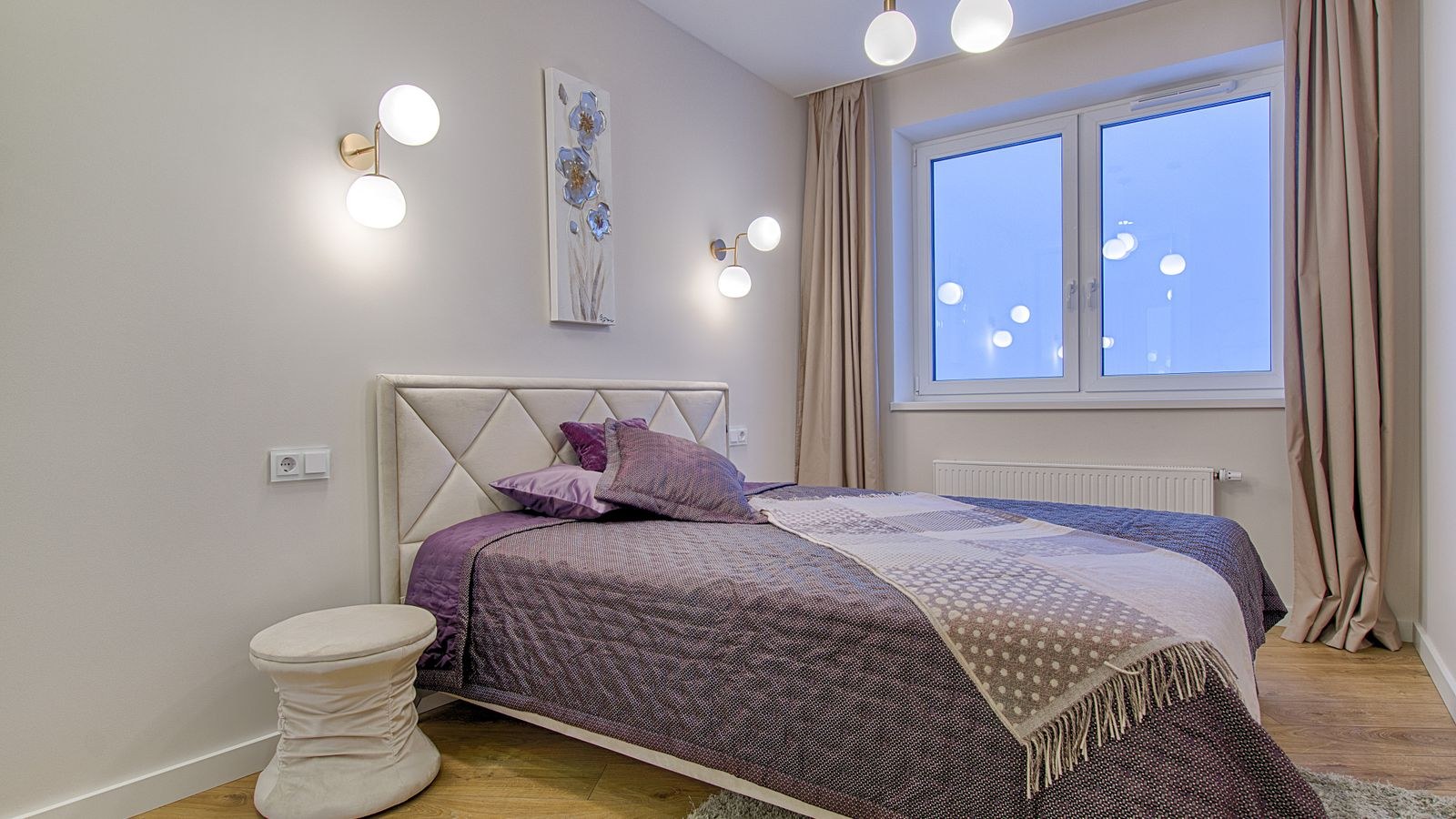 Soft bedroom lighting from a wall mounted fixture beside a headboard