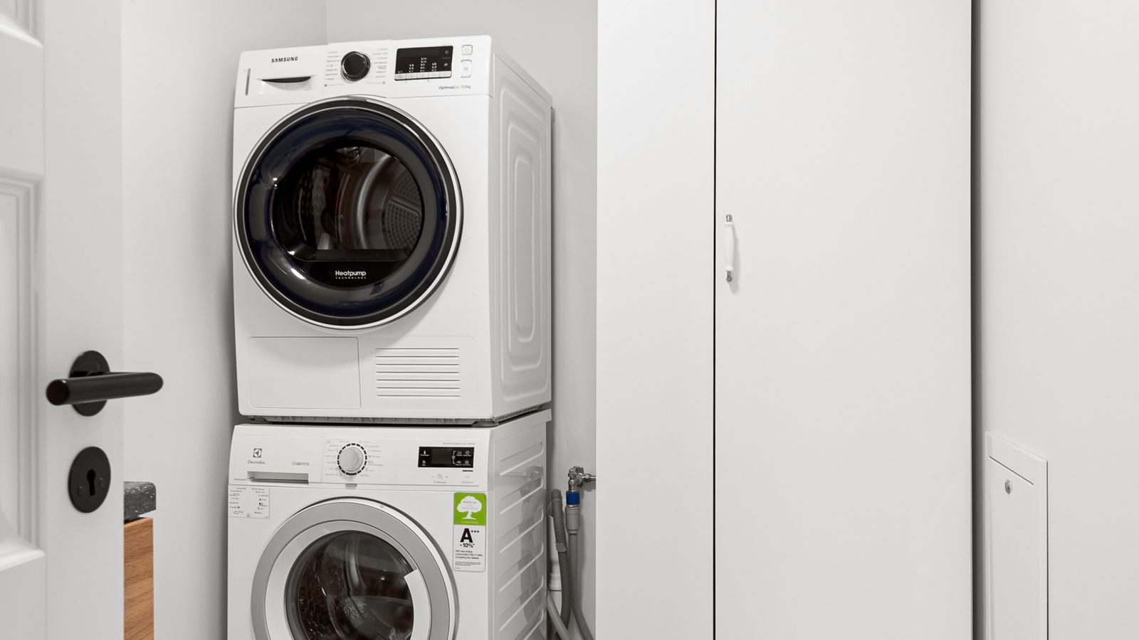 Stacked washer and dryer in a compact minimalist apartment laundry area