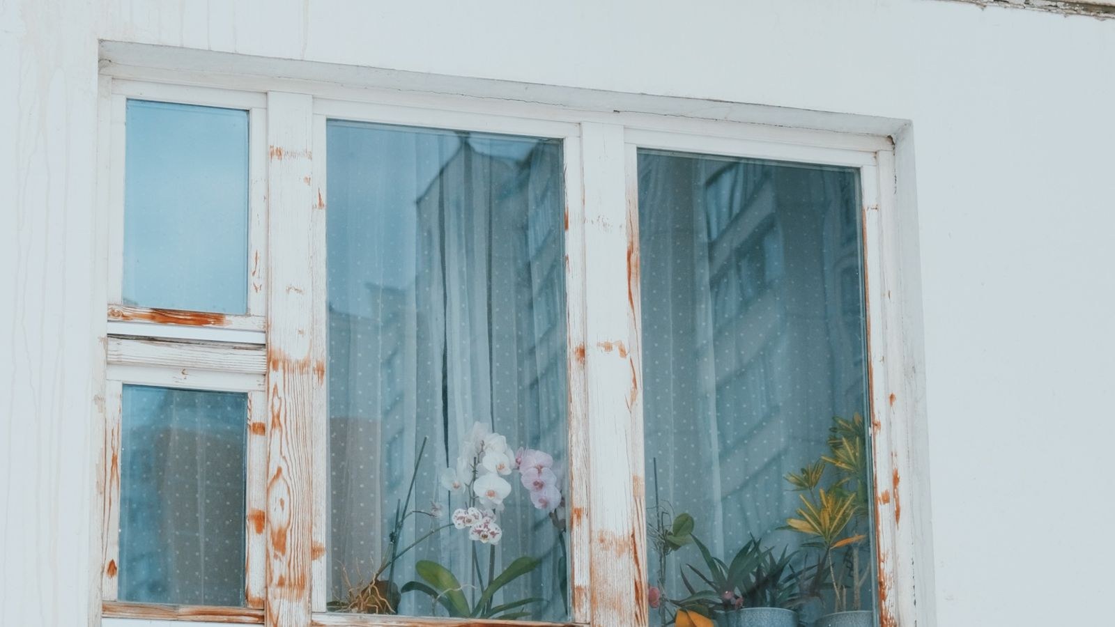 Detailed view of a window with an air conditioner unit installed on a building wall