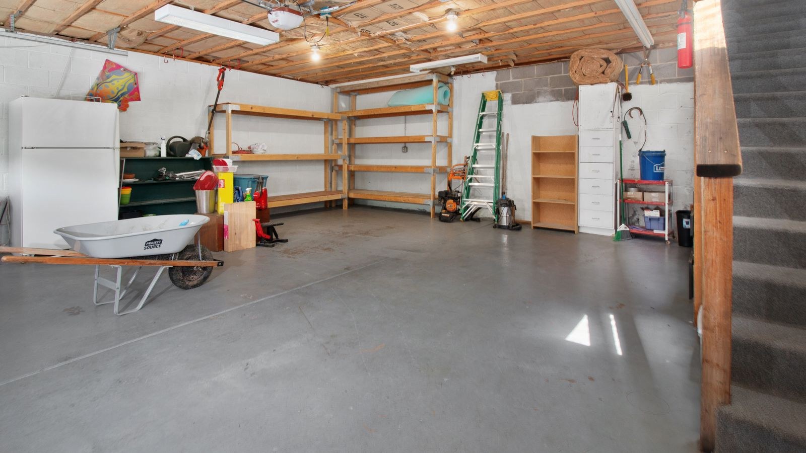 Spacious garage with storage shelves lit by overhead LED shop lights