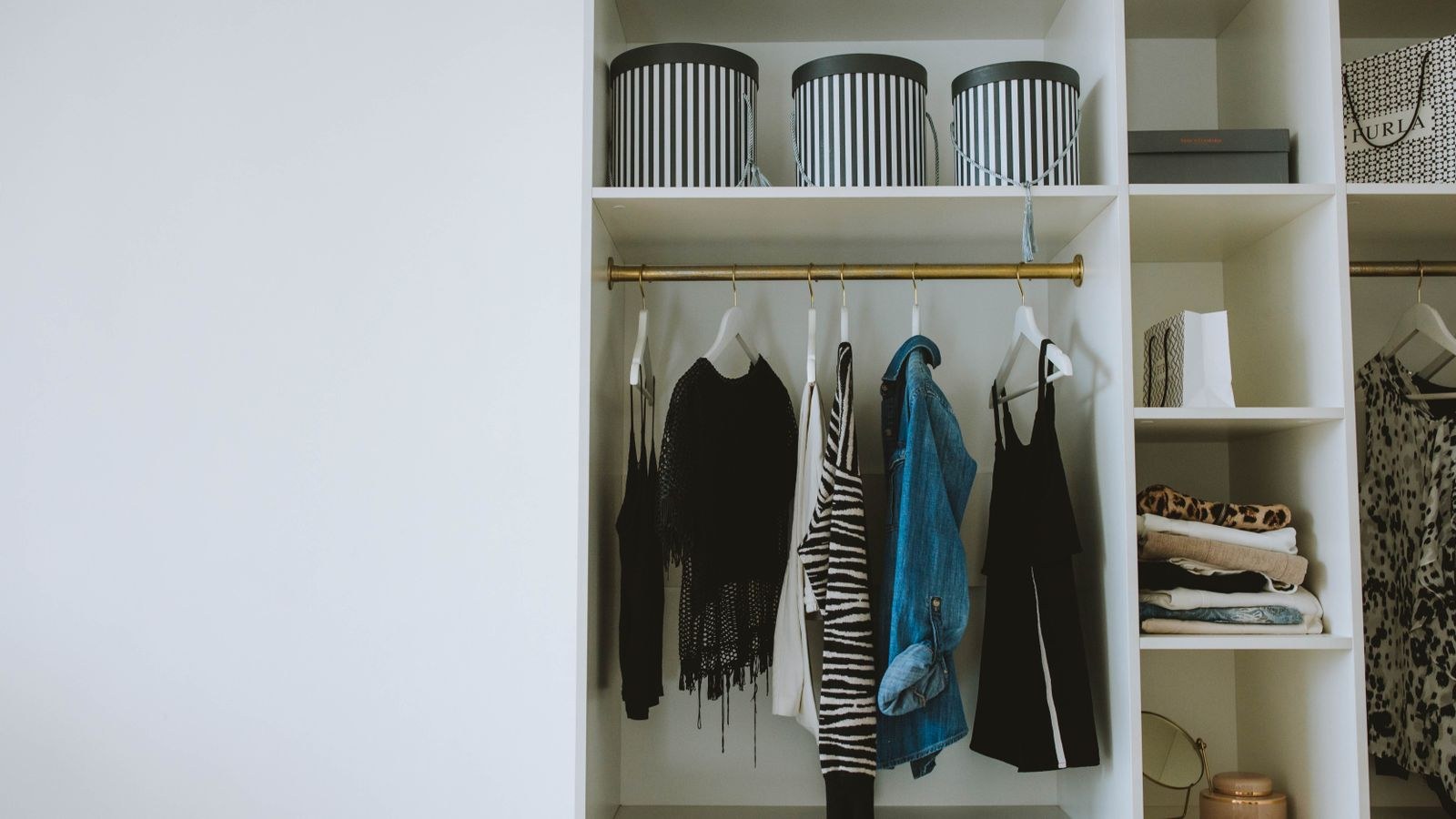 Organized wardrobe with clothes hangers and storage boxes under motion sensor lighting