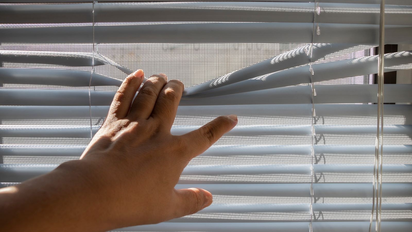 Close up of blind slats tilted open inside a window recess