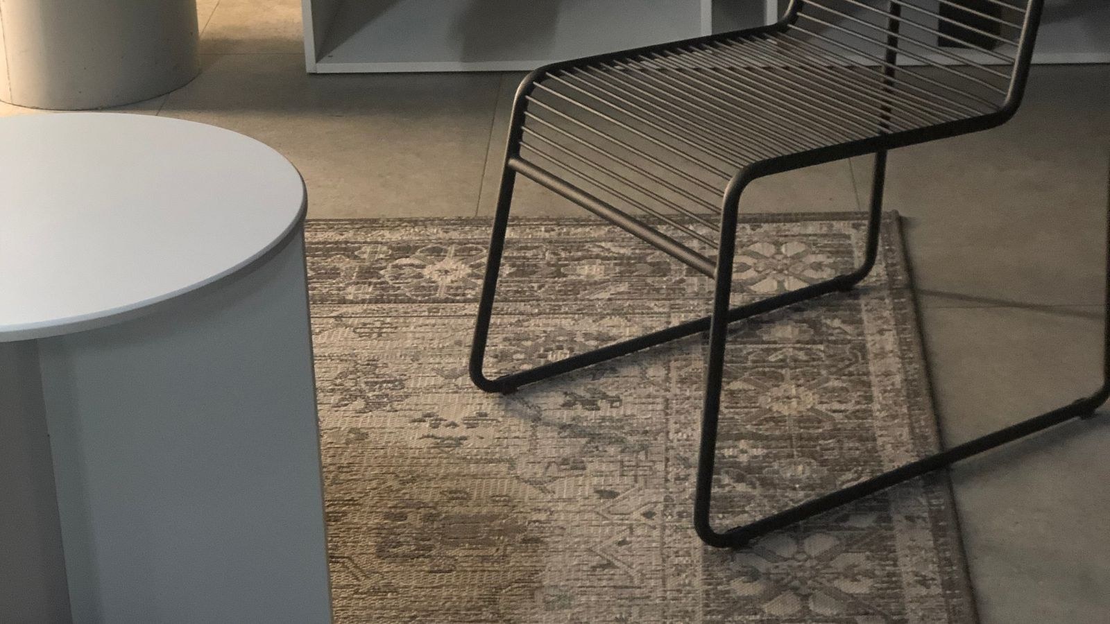 Decorative patterned rug layered over a neutral base rug beside a coffee table