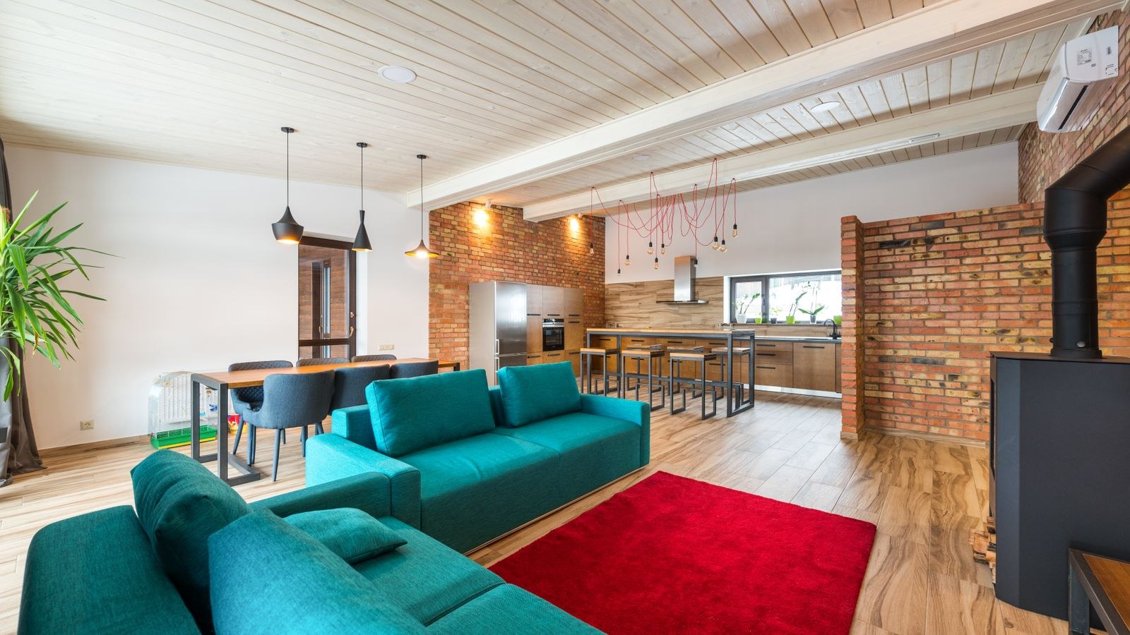 Modern living room with a red patterned rug layered over neutral flooring
