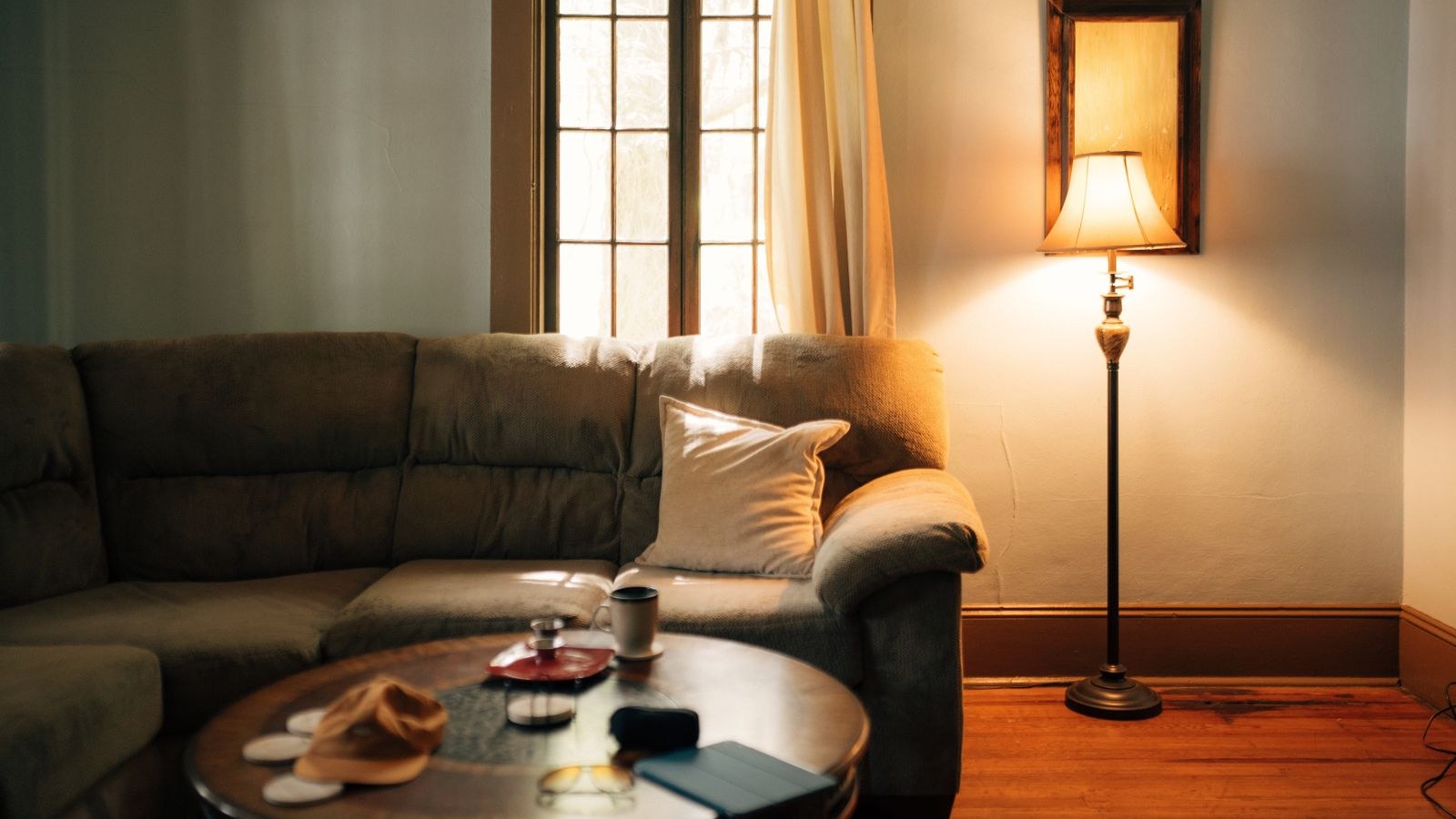 Warm living room interior with sofa, coffee table and a floor lamp