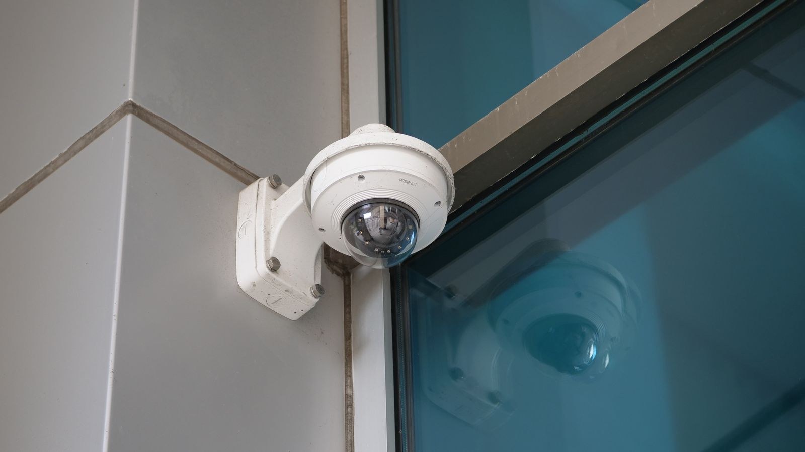 Security camera mounted on a building corner using a no-drill bracket