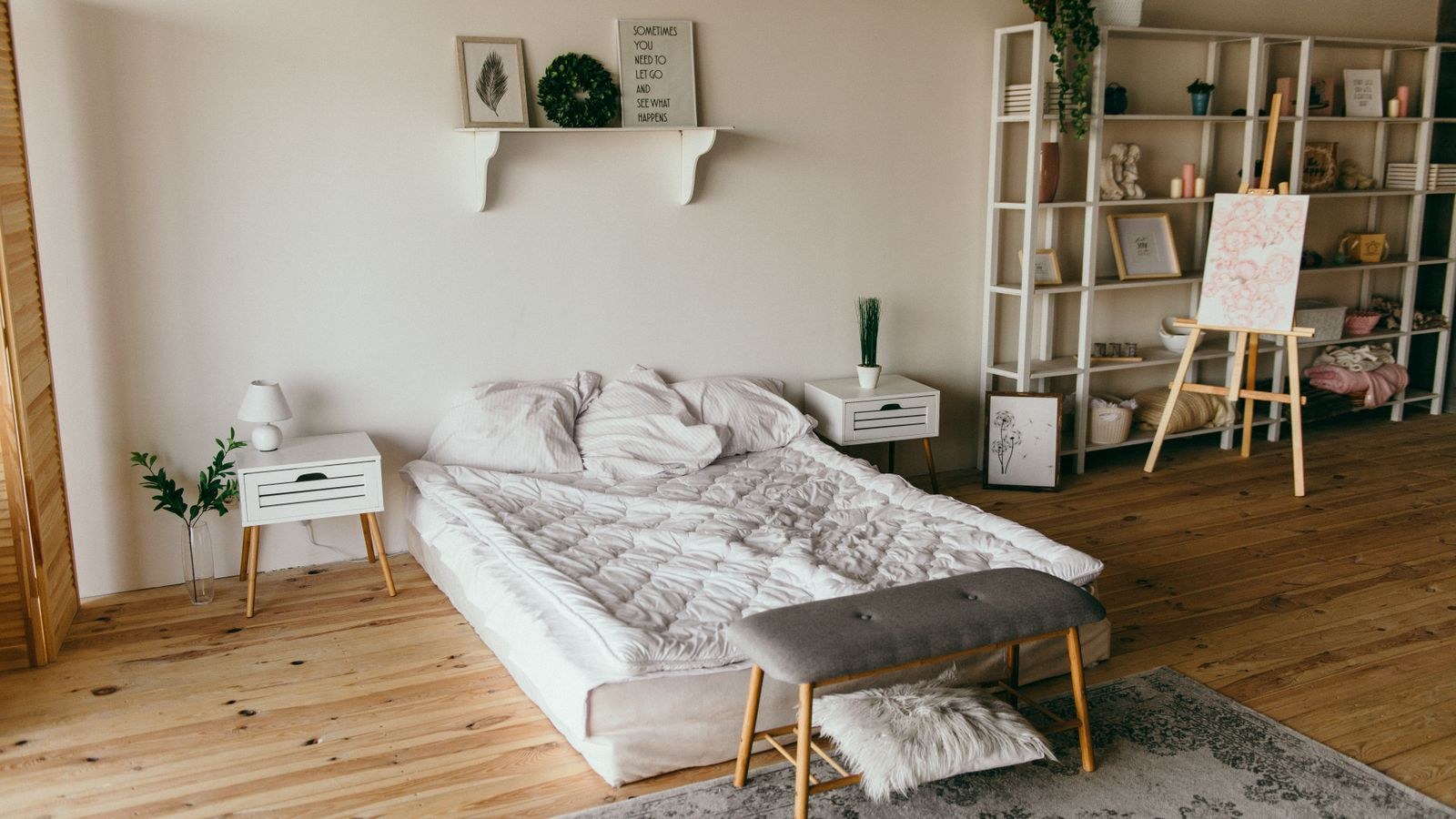 Small bedroom with low bed and wall shelf storage above for vertical organization