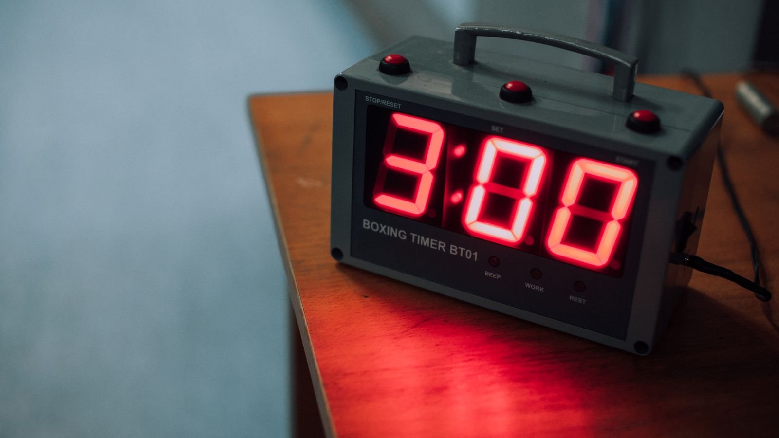 Digital timer with an LED display resting on a wooden surface