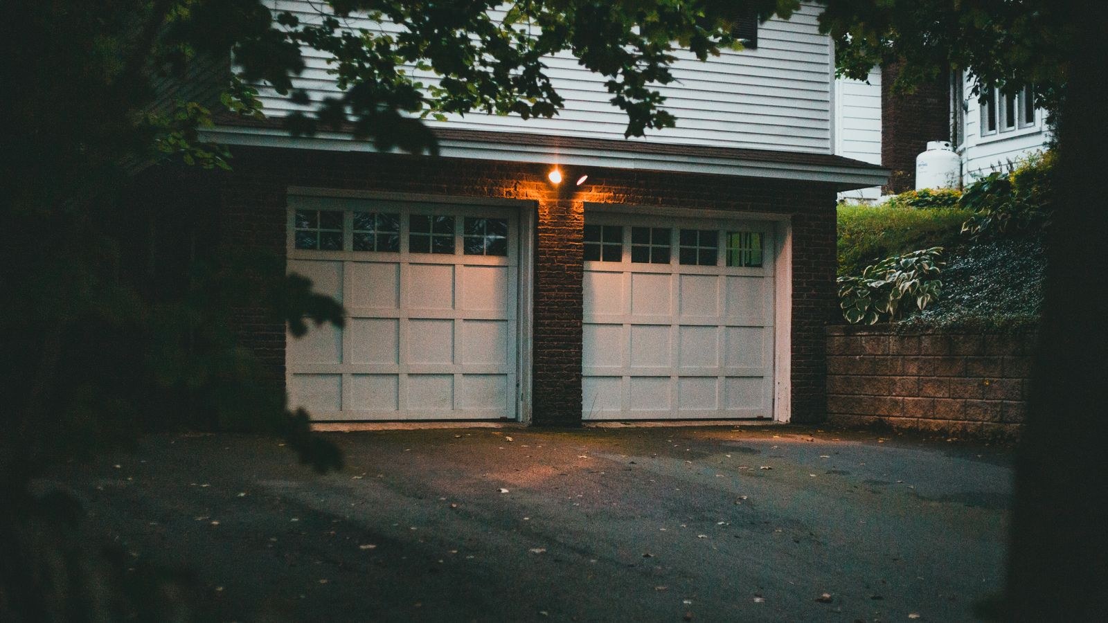 Suburban garage lit at night by exterior security lighting