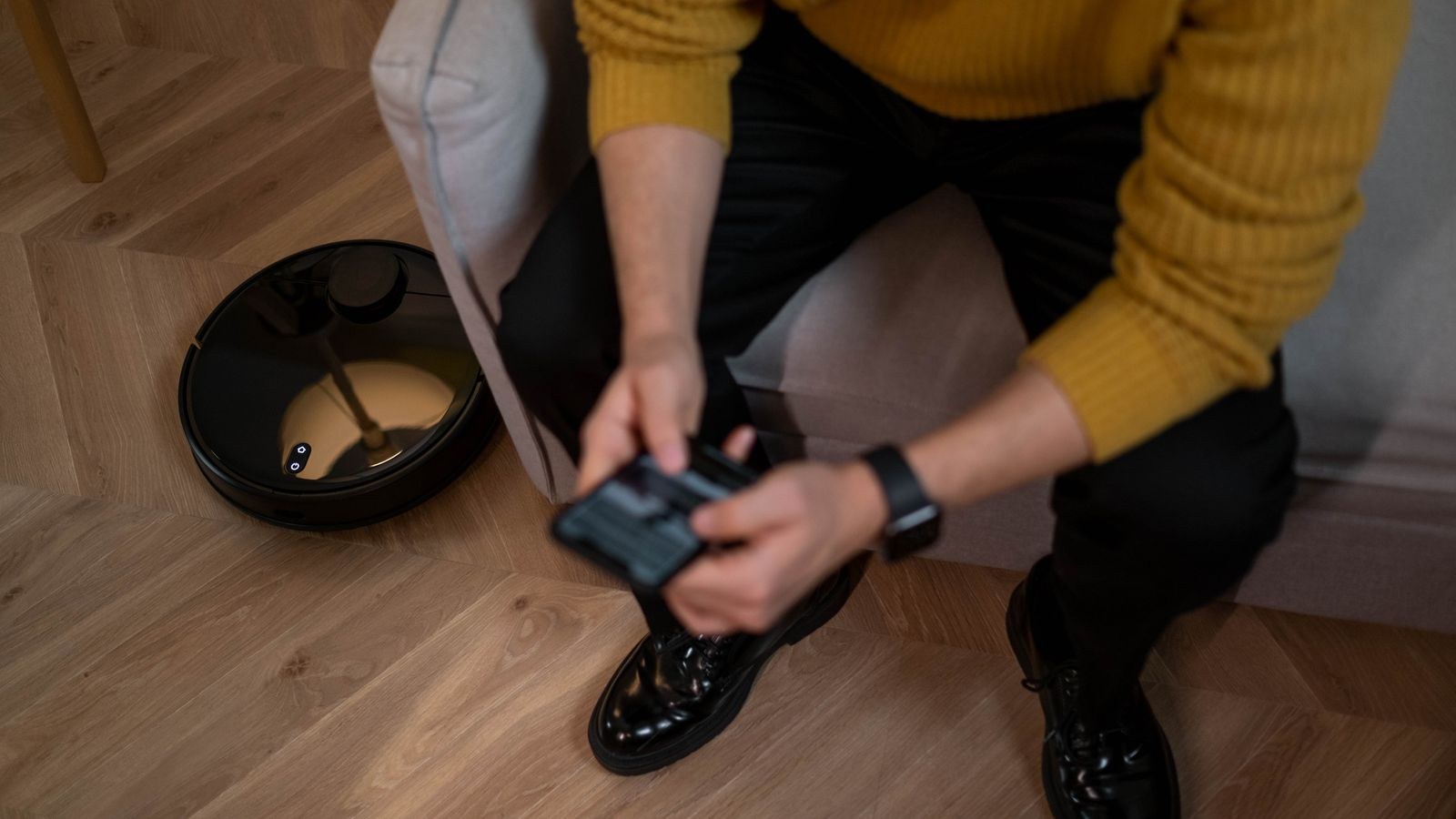 Robot vacuum cleaning under a table in a tidy modern home
