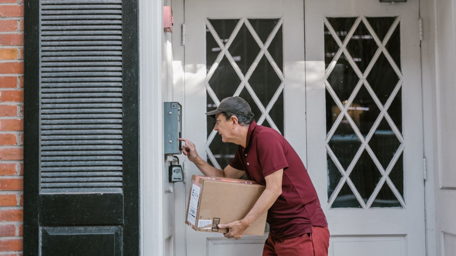 Courier delivering a parcel at a residential front door with a package drop zone