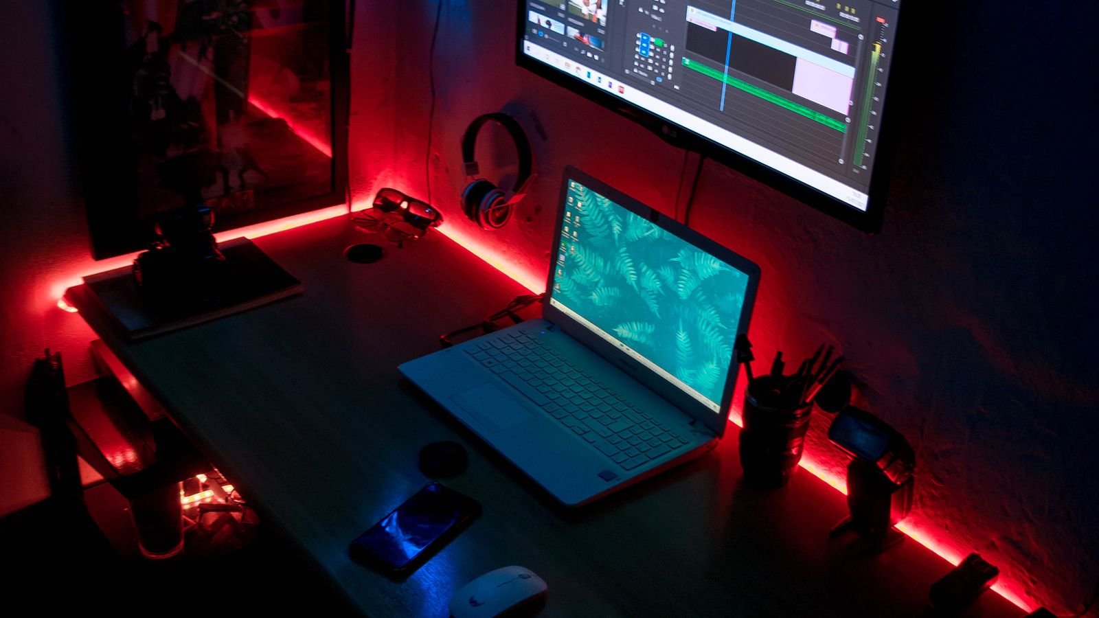 Color-changing LED strip lighting creating a purple and blue glow along a bedroom wall