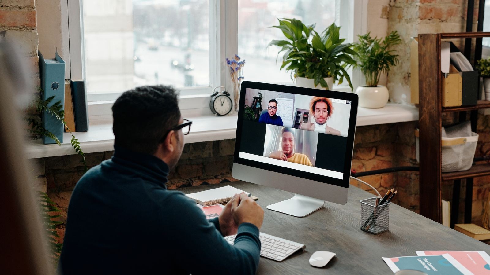 Desk lamp positioned beside a monitor to light a person during a video meeting