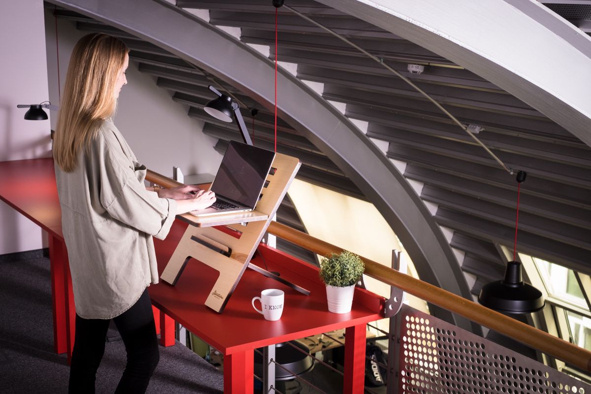 Person adjusting an electric standing desk to elbow height