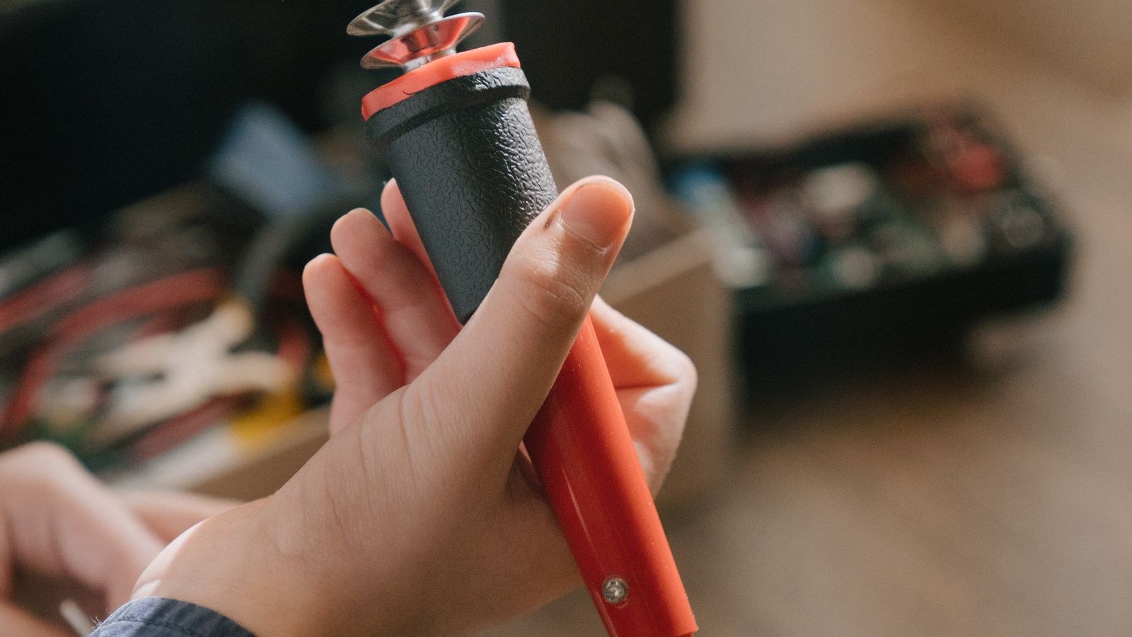 Hand holding a fine tip soldering iron ready for LED strip wiring work