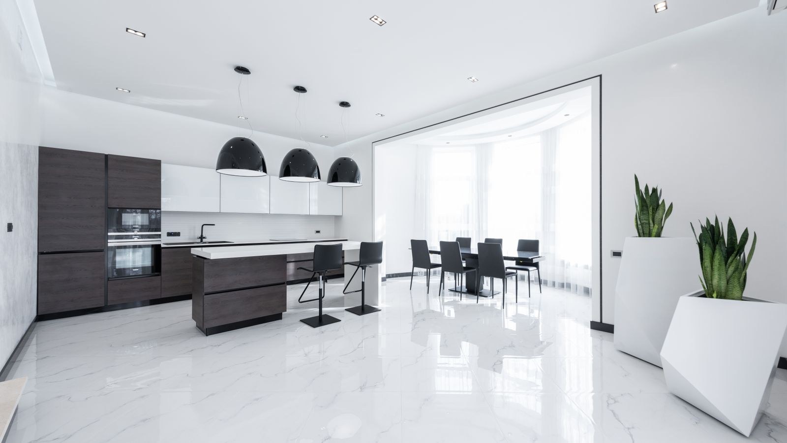 Kitchen counter and cabinets lit evenly by recessed can lights in the ceiling
