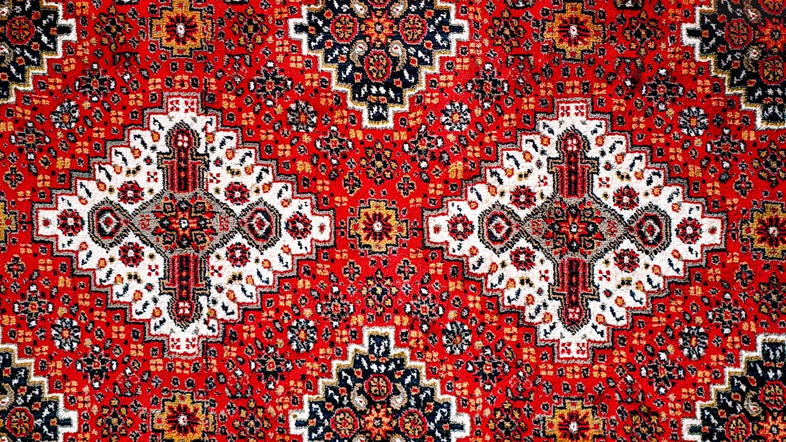 Close up of a woven rug edge and pattern detail showing the backing and pile