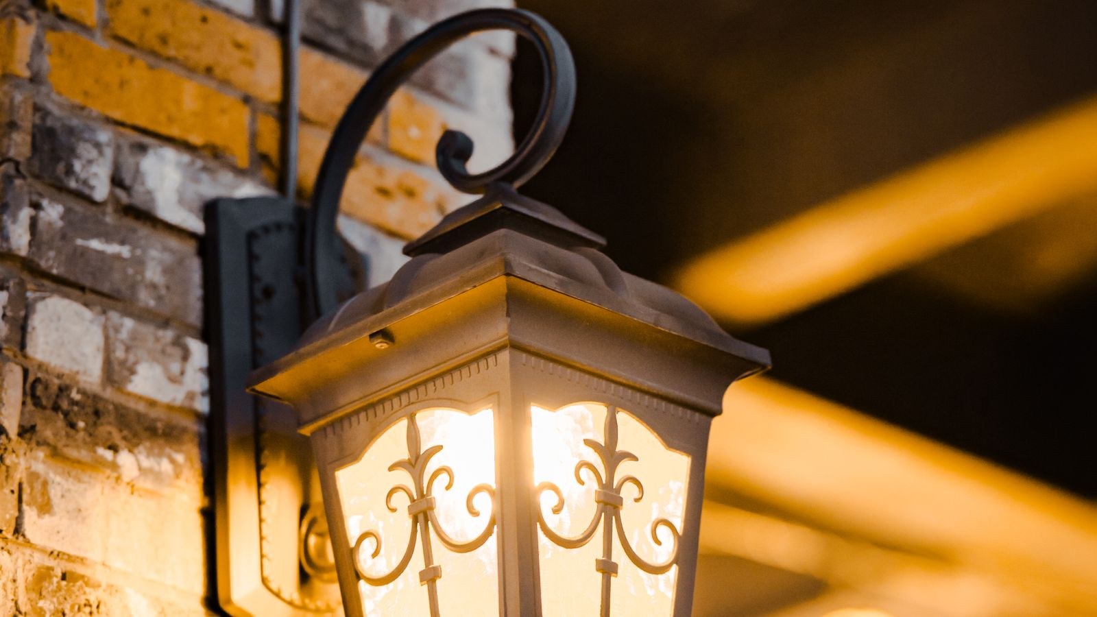 Outdoor security light mounted on a house wall above a garden path