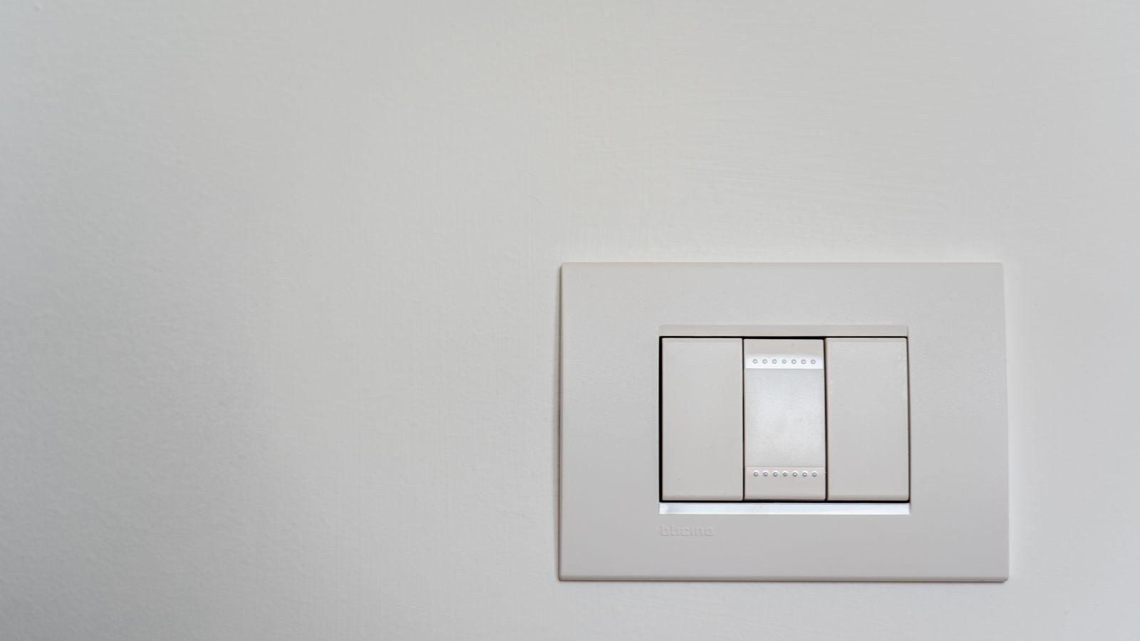Modern white light switch on a wall ready for a continuity test
