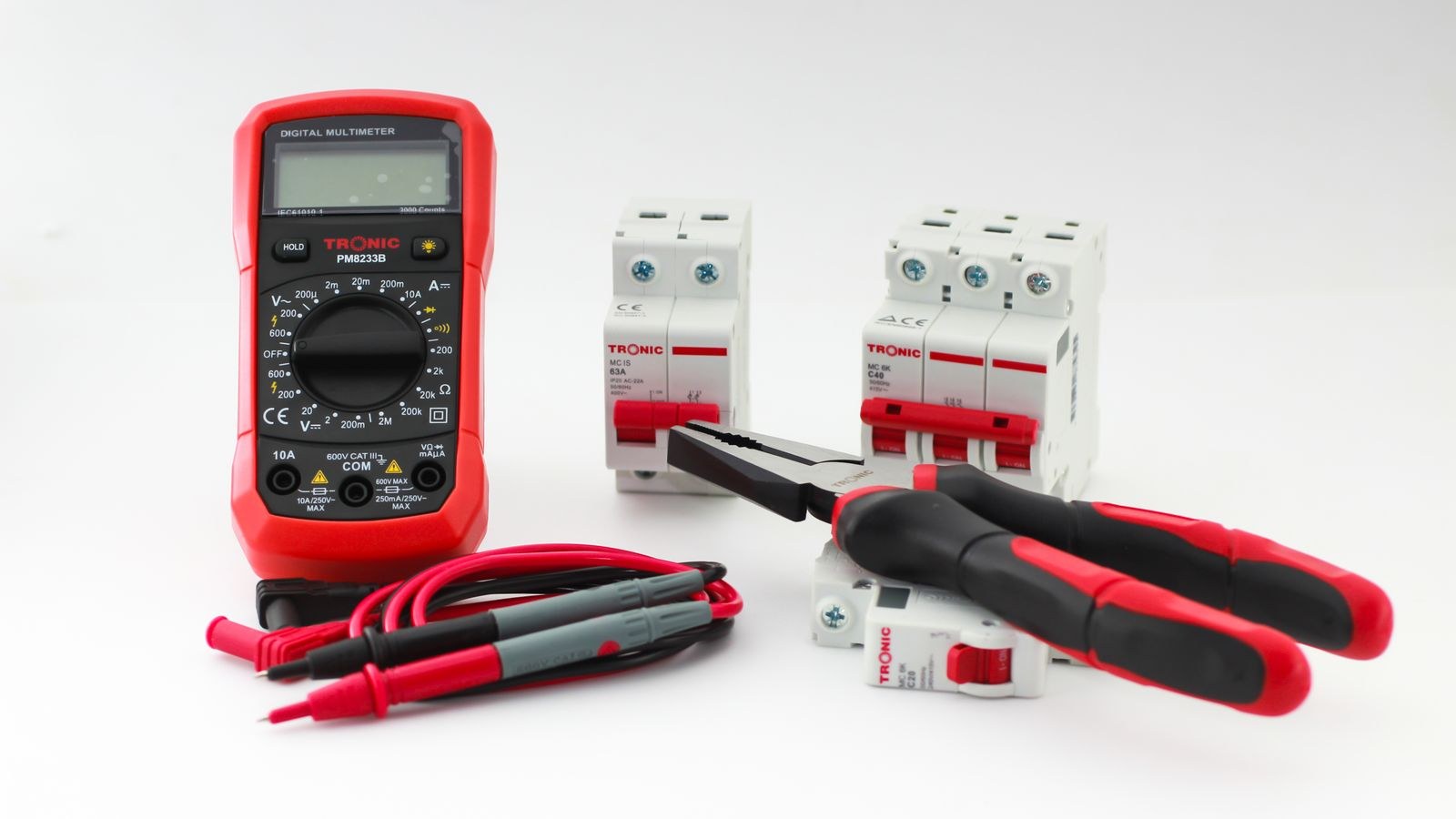 Multimeter alongside electrical tools and breakers used for switch testing